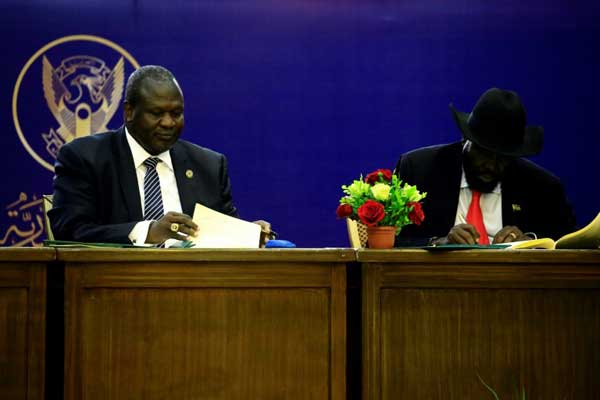 رئيس جنوب السودان سلفا كير وزعيم المتمردين رياك مشار خلال حفل توقيع اتفاق تقاسم السلطة في الخرطوم في الخامس من أغسطس 2018