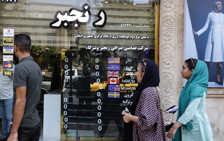 مواطنون إيرانيون أمام محول للعملات في طهران 