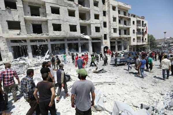 سوريون يتجمعون في موقع انفجار سيارة في مدينة إدلب بتاريخ 2 أغسطس 2018