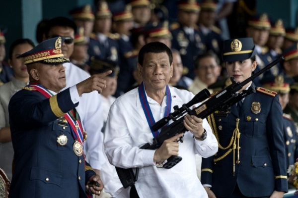 دوتيرتي يحمل بندقية قناصة خلال مراسم تسلم وتسليم قيادة الشرطة في مانيلا