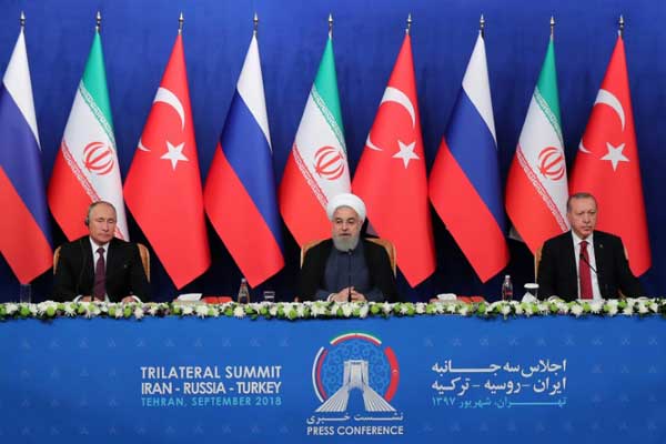روحاني (وسط) خلال مشاركته في مؤتمر صحافي مع نظيريه التركي أردوغان (يمين) وبوتين في طهران بتاريخ 7 سبتمبر 2018 في صورة نشرها مكتبه