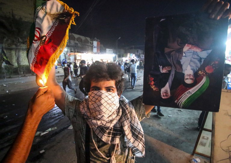 محتج في البصرة يحرق علم إيران