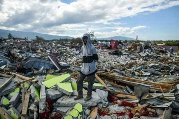 رجل يقف وسط الدمار في بيتوبو في 8 أكتوبر بعد الخراب الذي خلفه الزلزال