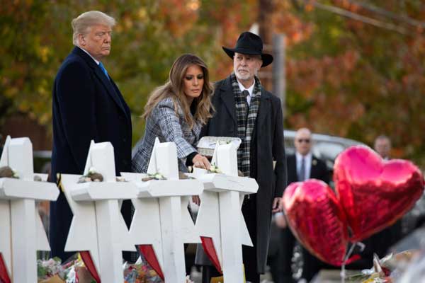 ترمب وزوجته ميلانيا يضعان ورودًا بيضاء عند نصب تذكارية للضحايا أمام الكنيس اليهودي في بيتسبرغ الثلاثاء 30 أكتوبر 2018