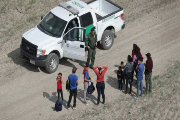 طالبو لجوء يتحدثون مع دورية أميركية بعد عبور الحدود مع المكسيك بتاريخ 7 نوفمبر 2018 في ميشن في ولاية تكساس