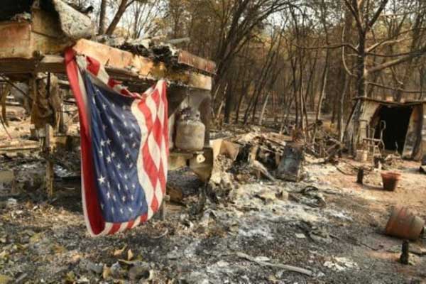علم أميركي فوق منزل نقال احترق في منطقة باراديس في كاليفورنيا بتاريخ 18 نوفمبر
