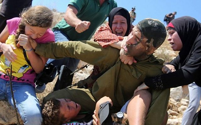 فتيات فلسطينيات يحاولن تخليص فتى فلسطيني من الاعتقال