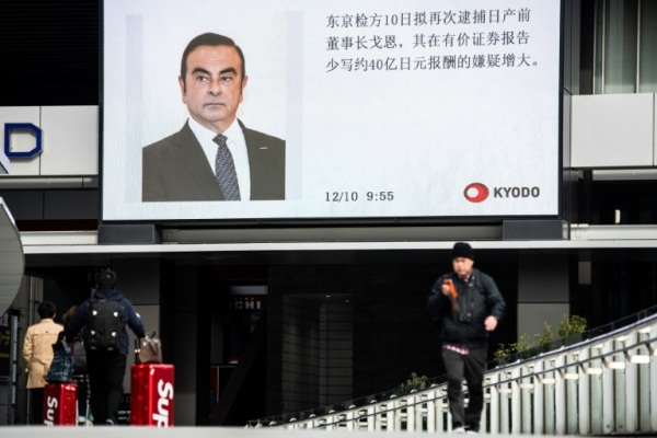 شاشة ضخمة في أحد شوارع طوكيو تنقل برنامجا إخباريا يتحدث عن رئيس شركة نيسان سابقا كارلوس غصن
