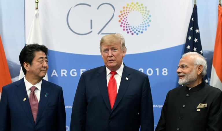  ترمب متوسّطاً رئيسي الوزراء الهندي ناريندرا مودي (يمين الصورة) والياباني شينزو آبي خلال اجتماع ثلاثي على هامش قمة مجموعة العشرين في بوينوس آيرس في 30 نوفمبر 2018. 