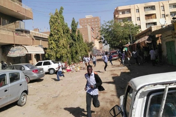 محتجون سودانيون يفرون من الغاز المسيل للدموع خلال تظاهرة في الخرطوم 