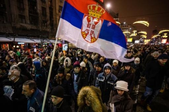 محتجون يرفعون العلم الصربي في بلغراد في 12 كانون الثاني/يناير 2019