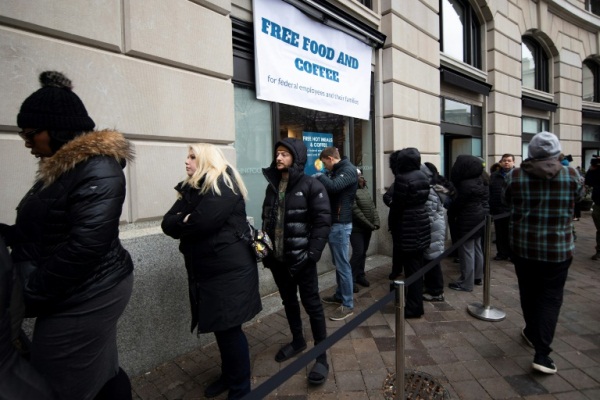 موظفون في الإدارات الفدرالية المتوقفة عن العمل أمام مطعم يوفر لهم طعاماً مجانياً في العاصمة واشنطن