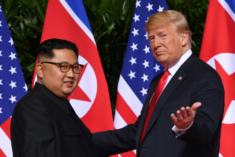 صورة من الارشيف التقطت بتاريخ 12 حزيران/يونيو 2018 تظهر الرئيس الأميركي دونالد ترمب (يمين) اثناء لقائه زعيم كوريا الشمالية في سنغافورة