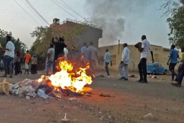 محتجون سودانيون يسيرون بجانب حريق خلال تظاهرة مناهضة للحكومة في مدينة أم درمان في 29 كانون الثاني/يناير 2019