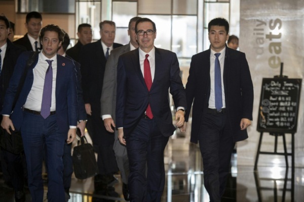 وزير الخزانة الأميركي (وسط) ستيفن منوتشين يعود إلى الفندق مقر إقامته بعد انتهاء المباحثات مع المسؤولين الصينيين