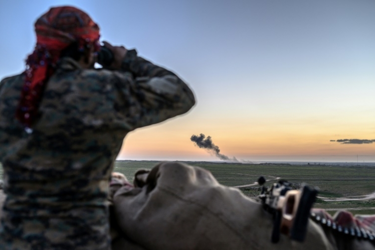 مقاتل من قوات سوريا الديموقراطية يستخدم منظارا لمراقبة جيب تنظيم داعش الأخير في بلدة الباغوز في شرق سوريا في 19 فبراير 2019