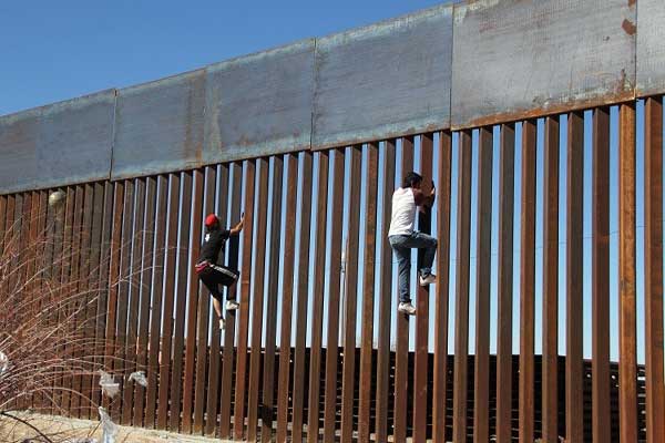 مهاجران يجتازان الحدود بين الولايات المتحدة والمكسيك