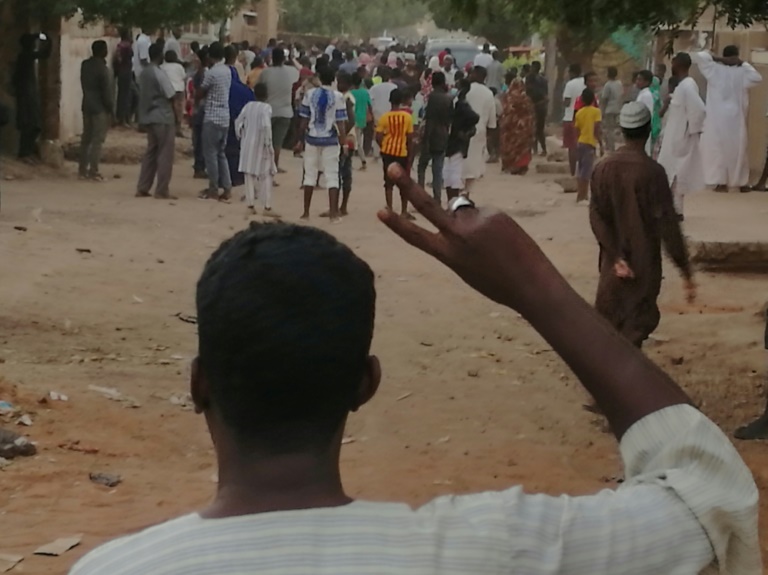 متظاهر سوداني يرفع علامة النصر خلال تظاهرة مناهضة للحكومة في الخرطوم بتاريخ 15 فبراير 2019
