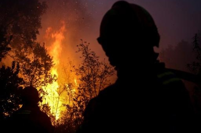رجال إطفاء يكافحون الحريق بالقرب من مونشيكي في منطقة الغارف السياحية في 8 اغسطس 2018