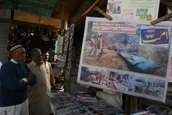 باكستانيون يقرأون عناوين الصحف في كراتشي بعد المواجهات مع الهند