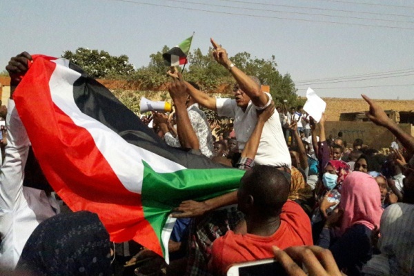 متظاهرون يلوحون بالعلم السوداني في مدينة أم ردمان قرب الخرطوم