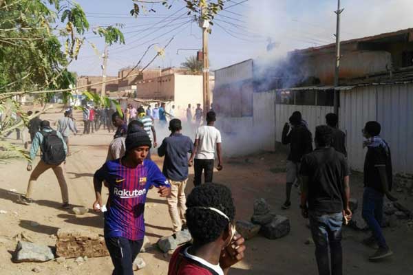 متظاهرون سودانيون يفرّون من الغاز المسيل للدموع خلال تظاهرة في حي بوريفي الخرطوم في 24 فبراير 2019