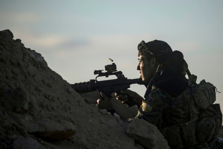 مقاتل من قوات سوريا الديموقراطية يراقب آخر مواقع تنظيم داعش في الباغوز
