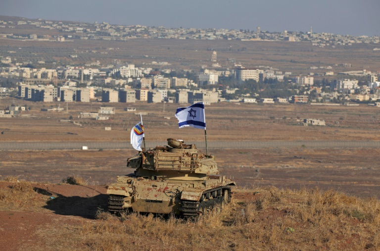صورة من الارشيف التقطت في 18 تشرين الأول/أكتوبر تظهر علما اسرائيليا يرفرف فوق أنقاض دبابة اسرائيلية على تلة في القطاع الذي تحتله إسرائيل من مرتفعات الجولان