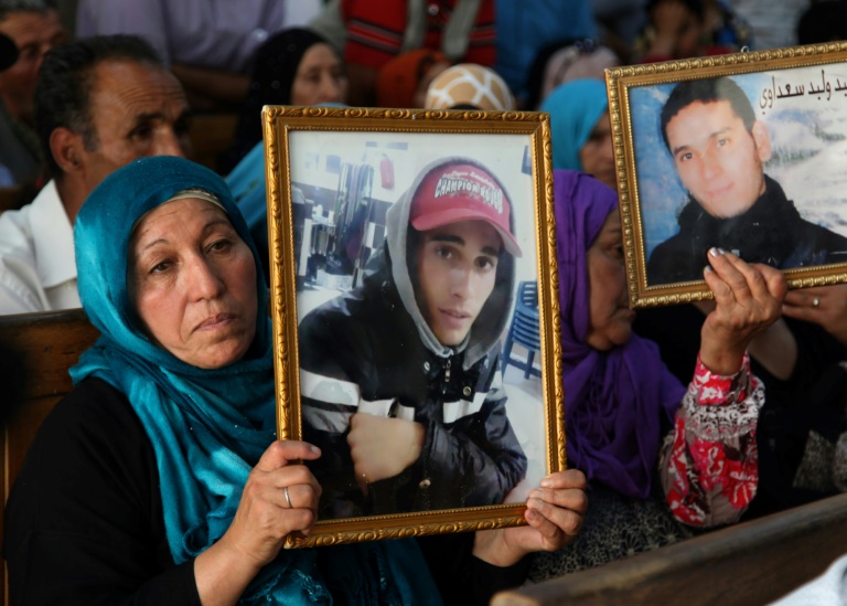 أفراد من عائلات ضحايا الثورة التونسية ضد نظام الرئيس زين العابدين بن علي يحملون في 13 تموز/يوليو 2018 صور أشخاص قتلوا خلال عهد بن علي