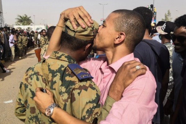 متظاهر سوداني يقبل أحد عناصر الجيش