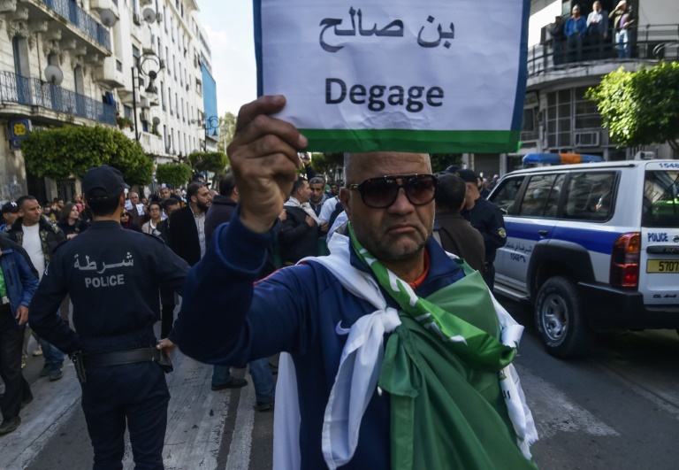 متظاهر يرفع لافتة تطالب برحيل الرئيس الانتقالي عبد القادر بن صالح في العاصمة الجزائرية في 10 نيسان/ابريل 2019