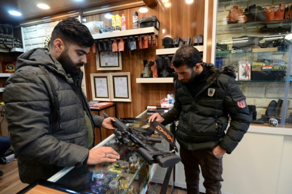 يتفقد بندقية في أحد محلات بيع الاسلحة في الموصل في 20 أبريل 2019