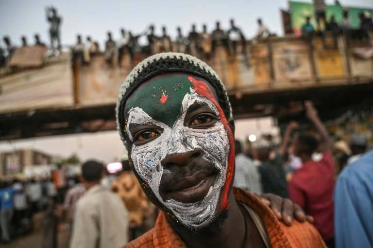 محتج سوداني رسم العلم السوداني على وجهه خلال احتجاج امام مقر الجيش في الخرطوم في 20 ابريل 2019