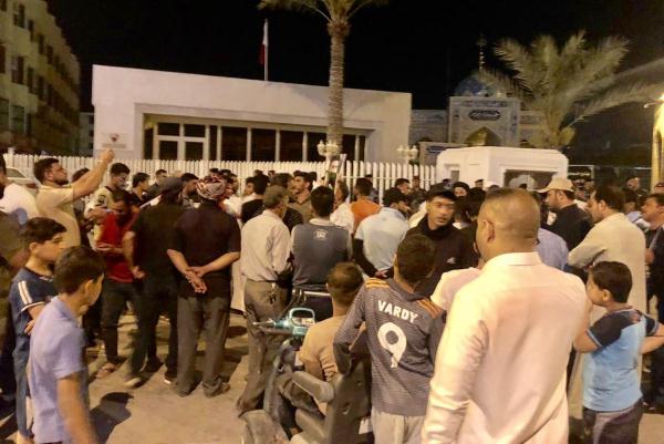 أنصار الصدر يتجمعون حاملين الزهور أمام مبنى القنصلية البحرينية في النجف