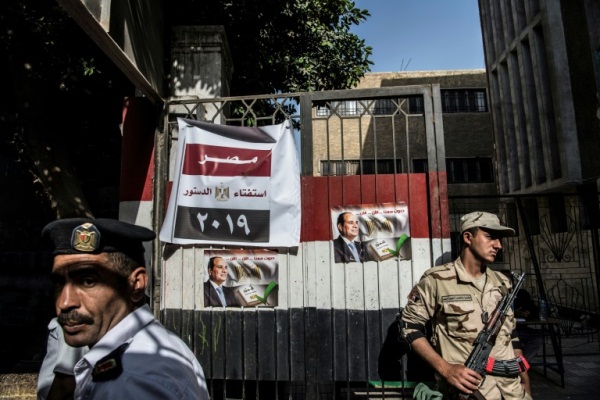 جندي مصري وشرطي يقفان أمام مركز اقتراع في القاهرة في 22 أبريل 2019