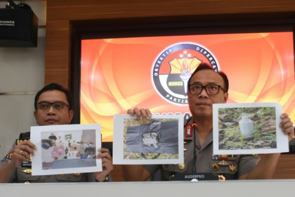 اثنان من ضباط الشرطة الإندونيسية يعرضان صور مشتبه بهم وأدلة مضبوطة خلال مؤتمر صحافي في جاكرتا
