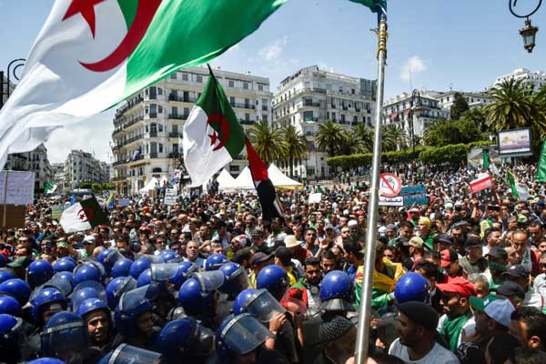 متظاهرون جزائريون يرفعون الأعلام الوطنية أمام مبنى البريد المركزي في العاصمة بتاريخ 17 مايو 2019