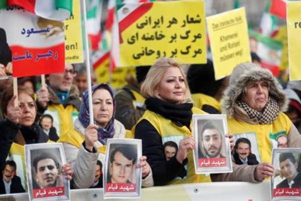 متظاهرون إيرانيون يحملون صور ضحايا الاحتجاجات ضد النظام