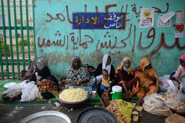 نسوة يحضرن طعام الإفطار في مكان الاعتصام أمام مقر القيادة العامة للجيش في الخرطوم في 10 مايو 2019