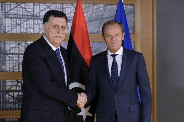 رئيس المجلس الأوروبي دونالد توسك (يمين) مصافحا رئيس حكومة الوفاق الوطني الليبية فايز السراج في بروكسل
