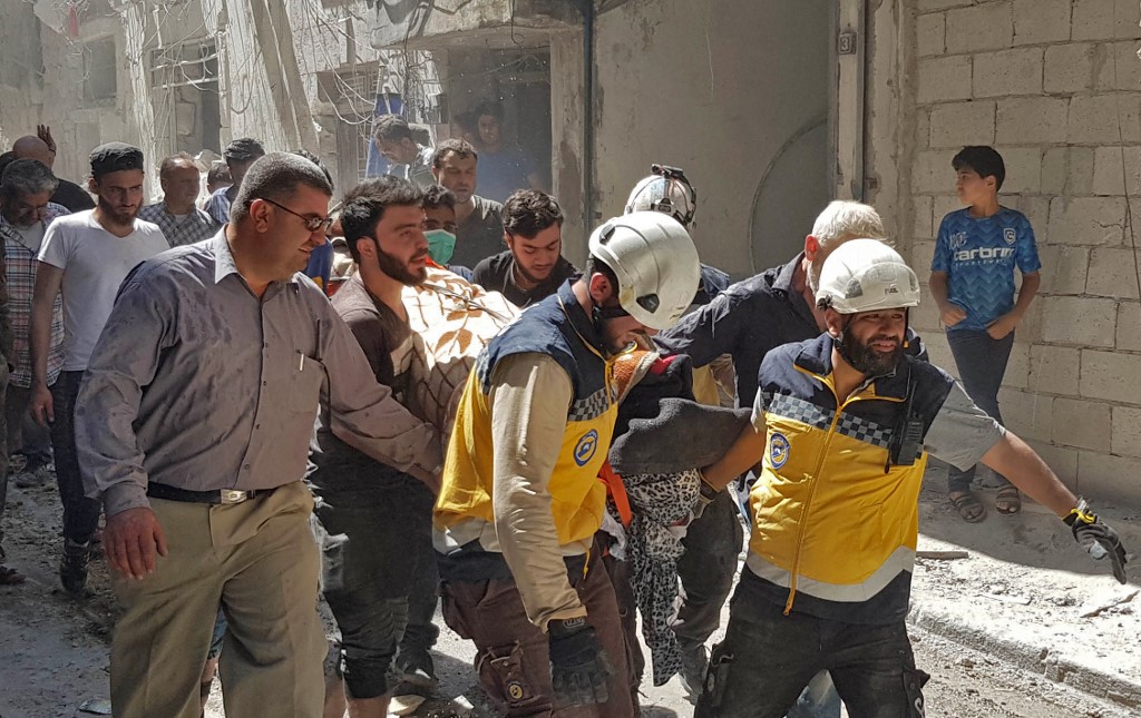مسعفون يغيثون مدنيين بعد تعرض ادلب لقصف من الطيران السوري