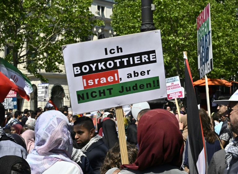 متظاهرة في برلين تحمل لافتة كتب عليها 