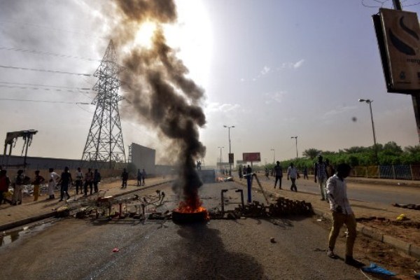 متظاهر سوداني يحرق إطارات في الخرطوم