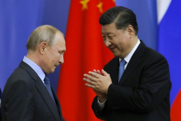 الرئيس الروسي فلاديمير بوتين (يسار) ونظيره الصيني خلال حفل تسليم شي جينبينغ شهادة من جامعة سان بطرسبورغ