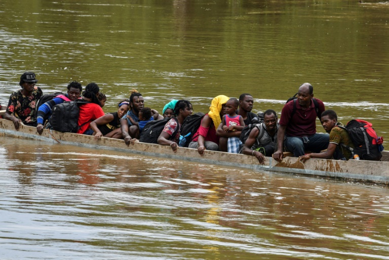مهاجرون من هايتي يعبرون نهرا بالمركب لبلوغ مركز الإيواء الموقت في قرية لا بينييتا في بنما في 23 مايو 2019