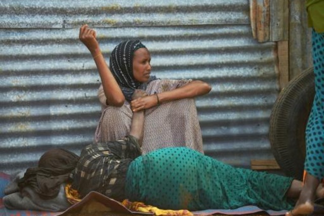 مسنة أنهكها الجوع تفترش الأرض قرب اينتها في مخيم للنازحين في بلدة بيدوة في جنوب غرب الصومال في 15 آذار/مارس 2017