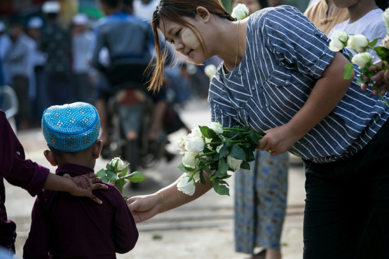 امرأة بوذية تقدم وردة بيضاء لطفل مسلم بعد أن أدى صلاة عيد الفطر في بلدة ثان لين على مشارف رانغون