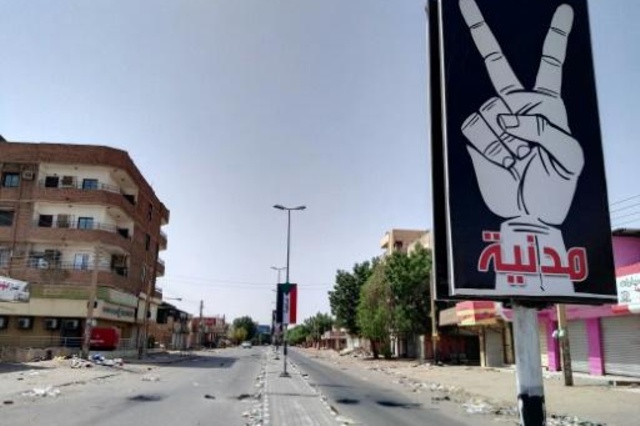 صورة التُقطت في 6 حزيران/يونيو 2019 يظهر فيها شارع فارغ في الخرطوم ولافتتان كتب على إحداها 
