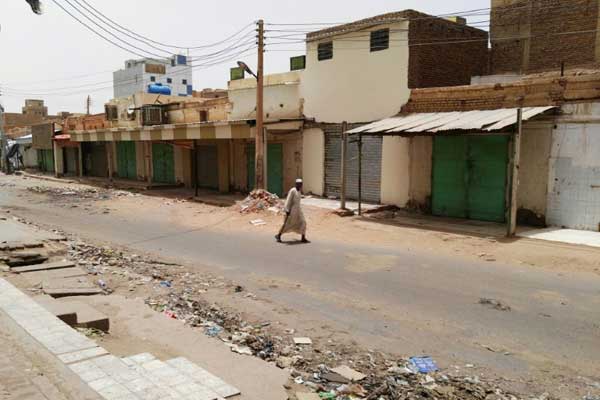سوداني يعبر شارعًا خاليًا من المارة وقد أقفلت فيه المحال التجارية بناء على دعوة إلى العصيان المدني في التاسع من يونيو 2019