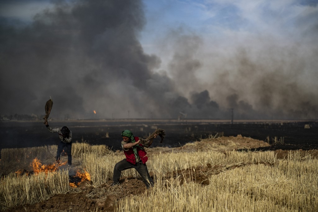 مزارعون في شمال سوريا يحاولون اطفاء نيران تلتهم محاصيلهم من القمح